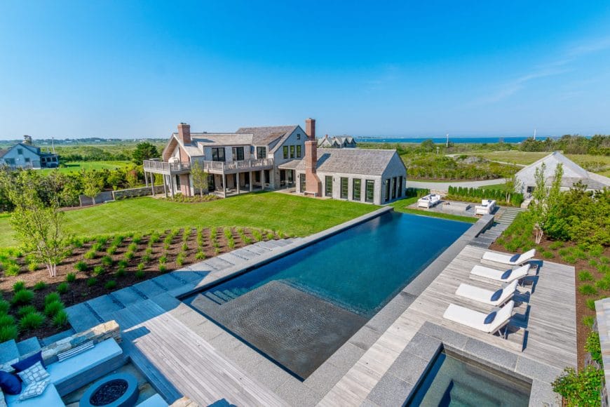222 Eel Point Road | Fisher Real Estate | Jen Shalley | $12,995,000 | Comfortable outdoor living areas and an infinity-edge pool makes this the ideal Nantucket home. French doors from the game room and a Nano door from the cabana all lead to the large built-in fire pit, seating areas, pool, hot tub, and outdoor shower. The surrounding 270+ acres of conservation land set the scene for jaw-dropping sunsets and water access is immediately across the way.