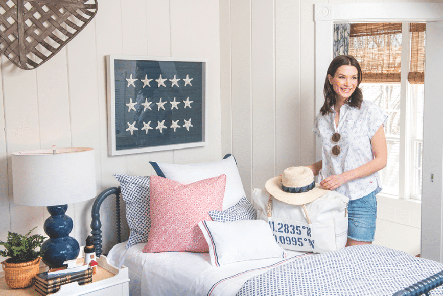 BLOUSE & HAT: Vineyard Vines, SHORTS: Mill & Grace, BAG & SUNGLASSES: 28 Centre Pointe | LINENS, “Laos” Red by Thibaut THROW PILLOW, Starfish SHADOW BOX, BEDSIDE TABLE, LAMP, & BAG available exclusively at 28 Centre Pointe